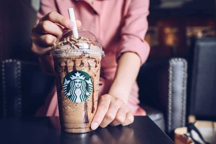 Iced blended coffee drink with chocolate drizzle held by a person