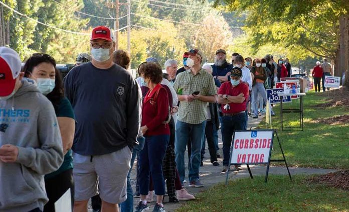 shutterstock_1834288405 Christian Jones and others waiting in a long line outside a polling place
