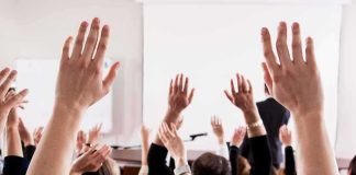 Audience raising hands in a lecture hall