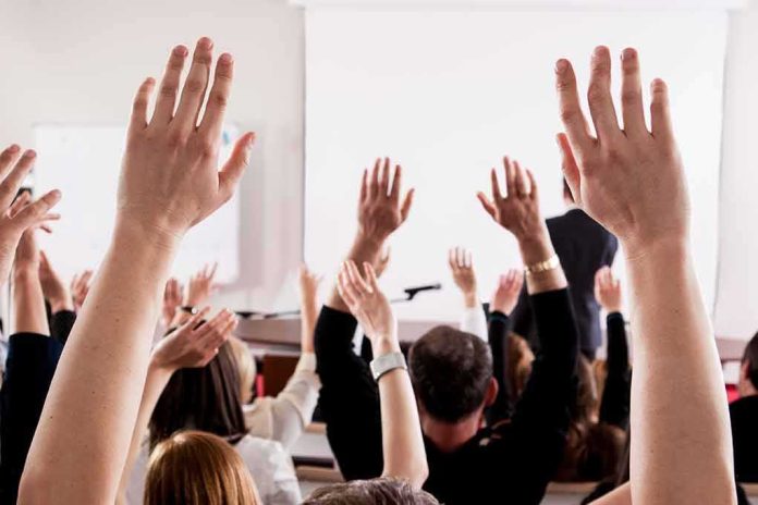 Audience raising hands in a lecture hall